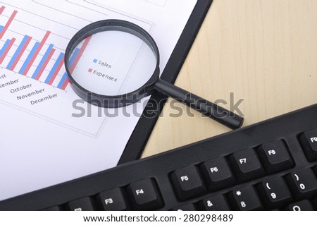 Magnifying Glass With Yearly Graph Bar Representing 