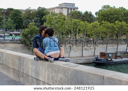 PARIS, FRANCE - SEPTEMBER 03, 2012: Young romantic couple kissing near the Eiffel Tower in Paris