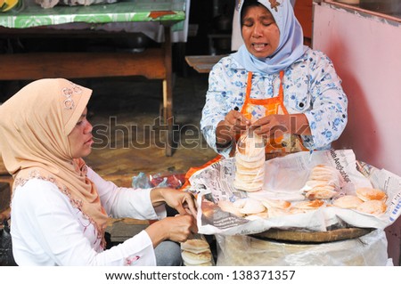 MEDAN,INDONESIA-MAY 26: Unidentified Womans sells traditional snack in Medan, Indonesia on May 26, 2011. Medan is fourth largest city in Indonesia with 90% of its population are Muslims.