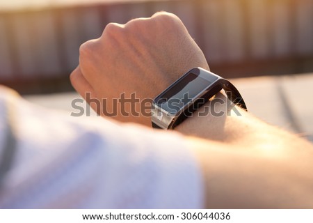 Running athlete man looking at smart watch