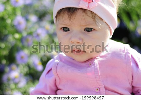 pretty little girl near a bush of flowers