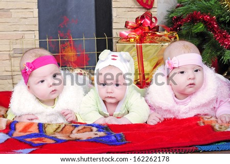 the boy and the Twins girls near a Christmas tree