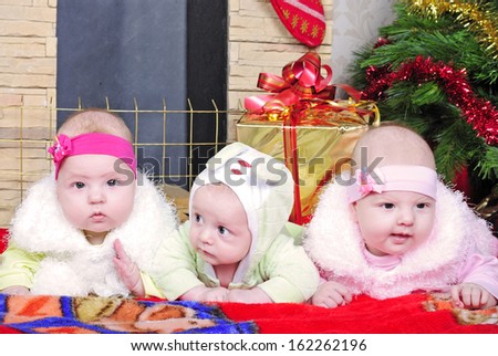 the boy and the Twins girls near a Christmas tree