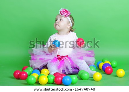 Small girl in rose suit on green background