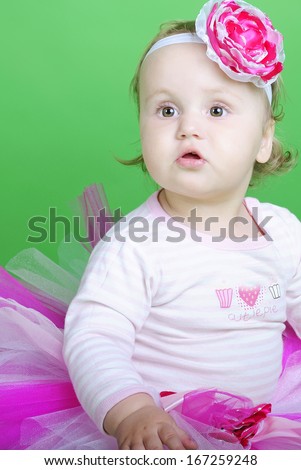 Small girl in rose suit on green background