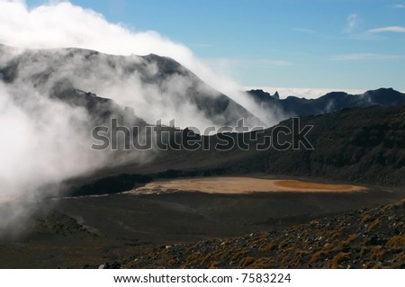 Red volcano crater lake and a cloud sitting on it as fog. Tongariro crossing, New Zealand