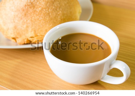 Hot coffee and bread on table