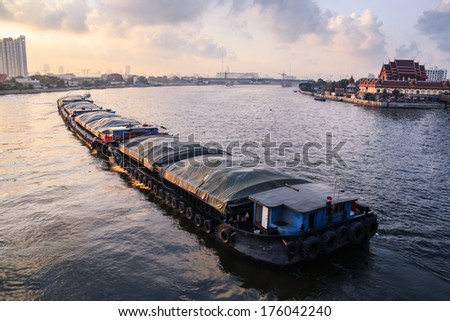 Boat pulled by a tugboat cargo carry the product of morning time at Thailand