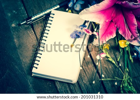 Flowers and a notepad on a desk