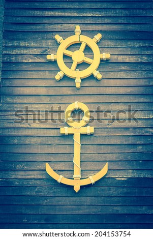 Ship anchor with steer wheel  on wood