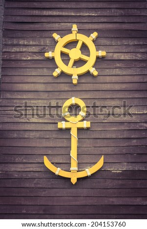 Ship anchor with steer wheel  on wood