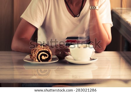 woman hands with cappuccino on a wood table