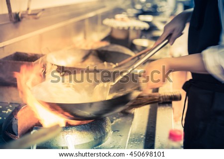 blurred chef of a restaurant kitchen, motion cooking, take photo low speed