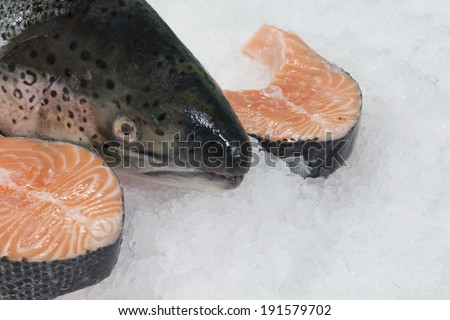 Salmon head and 2 salmon cutlets. fish background. fish on ice in market.
