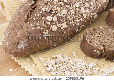 Close-up of black bread with wheat and decorated with wheat. On wooden board.