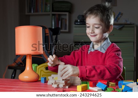 boy is arranging wooden toy constructor