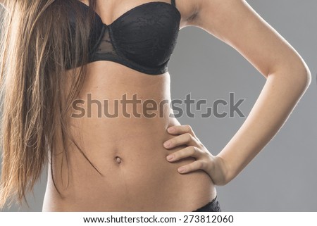 close up of beautiful sexy girl middle wearing black underwear. woman body isolated on gray studio background.