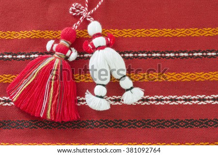 Bulgarian Martenitsa. It is a small piece of adornment, made of white and red yarn. They are worn from Baba Marta Day (March 1) until the wearer first sees a stork or budding tree.