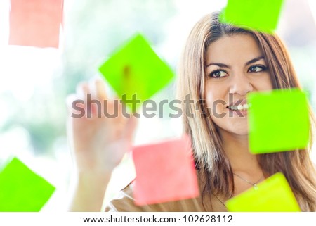 Beautiful business woman multitasking with lots of post-its