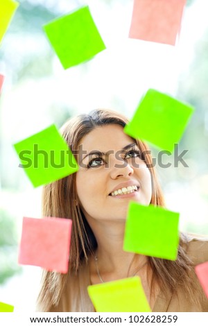 Multitask woman with post-its all around and smiling
