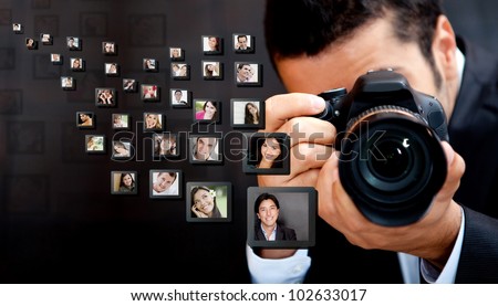 Male photographer holding the camera with pictures flying around Male photographer holding the camera with pictures flying around
