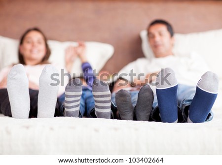 Family lying in bed together - focus on feet