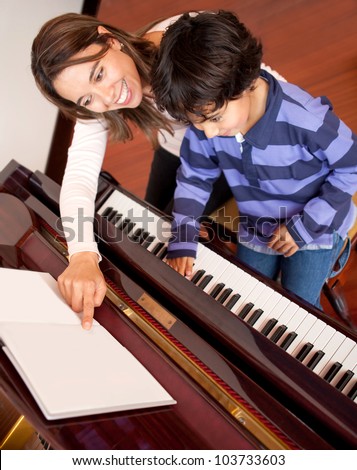 Young boy taking piano lessons at home