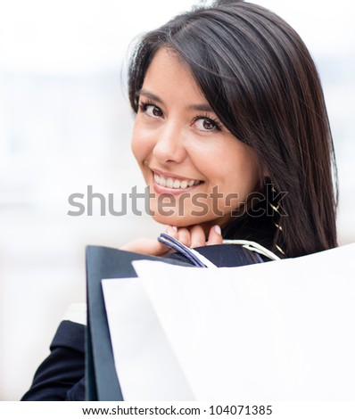 Happy Latin woman shopping and holding bags