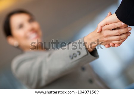 Welcoming business woman giving a handshake and smiling
