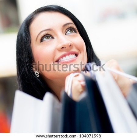 Happy female shopper holding bags at the shopping center