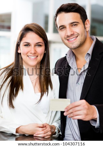 Couple holding a credit or debit card and smiling