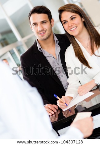 Couple at the reception of a hotel smiling