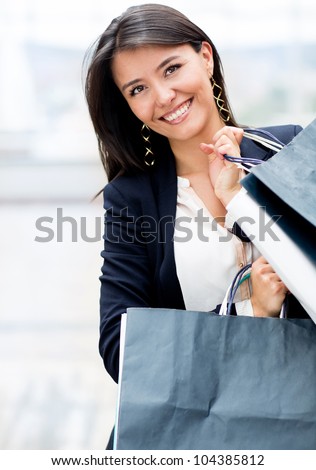 Latin woman shopping holding bags and looking happy