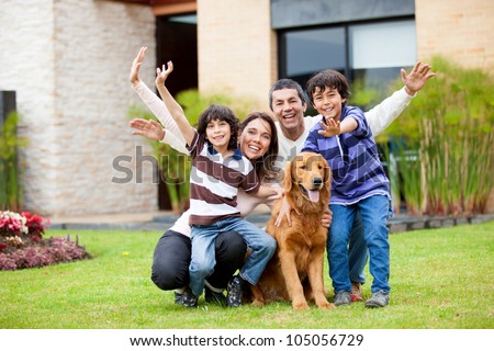 Happy family with a dog outside their house