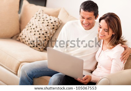 Couple at home going online on a laptop computer