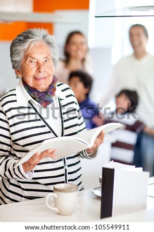 Grandma in the kitchen holding a recipe book