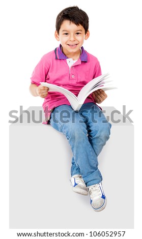 Happy kid reading a book and smiling - isolated over white background
