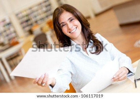 Woman working at the library and handling a paper