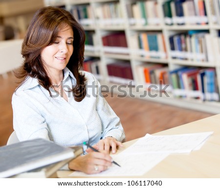 Female teacher grading exams at the library
