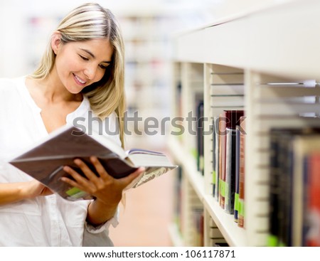 Beautiful woman reading a book at the library