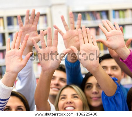 Group of students raising their hands to participate in class