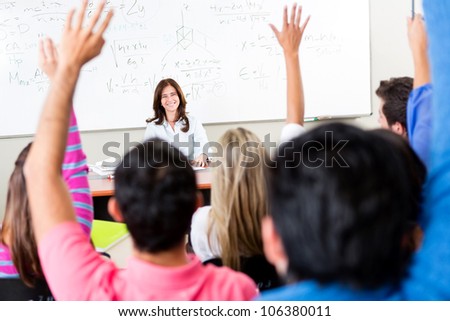 Students raising their hands and asking questions to the teacher Students raising their hands and asking questions to the teacher