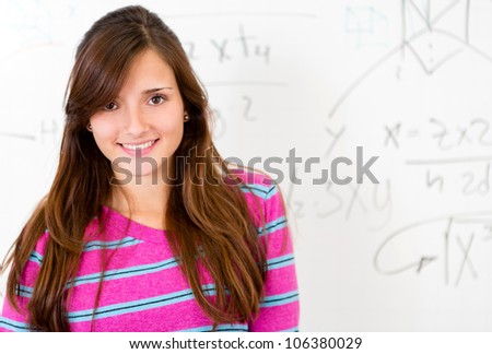 Beautiful female student smiling with a whiteboard at the background