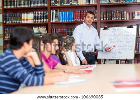 Male teacher with a group of college students in class
