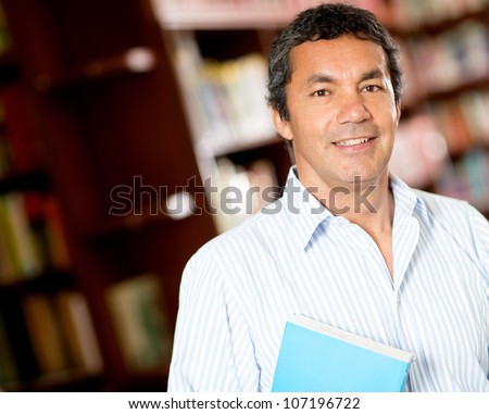 Old male university student smiling at the library