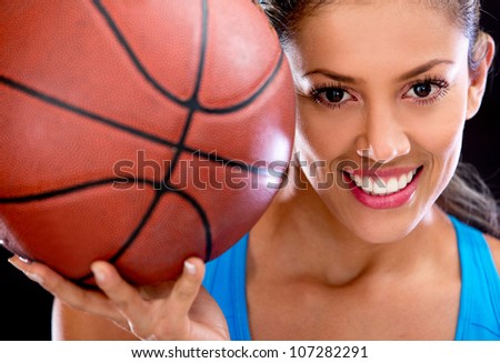 Beautiful woman portrait holding basketball and smiling