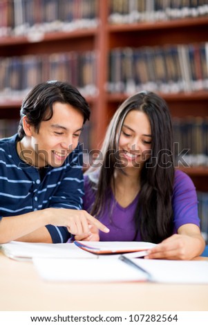 Young people studying at the library and smiling
