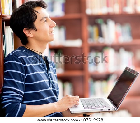 Man researching at the library with a laptop computer
