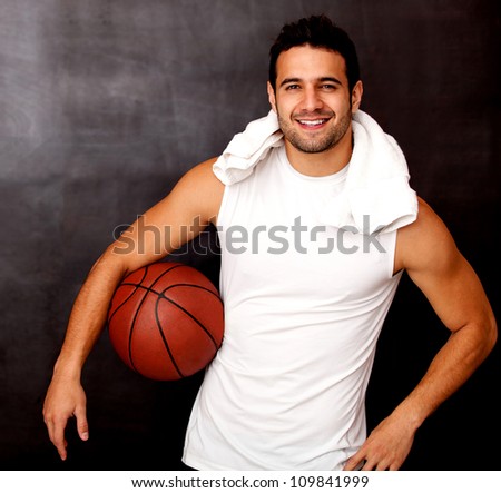 Male basketball player looking happy holding the ball