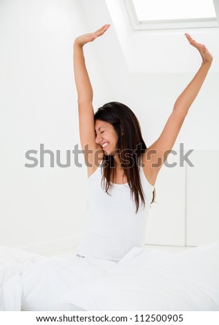 Lazy woman yawning in the morning on her bed